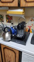 Overview of espresso machine, kettle, teapot and frother on countertop
