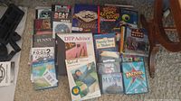 Assorted PC programs and games spread on carpet including jewel cases and boxes; titles visible such as You Don't Know Jack, Virtual Pool 2, DTP Advisor, MacGolf Classic, Myst, Mafia, The Movies