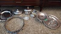 Group shot of all silver-plated items, casserole ring, lighter and small plates