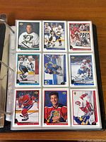 Binder open showing first nine cards featuring various NHL players