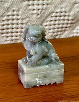 Front angled view of marble fu dog on wooden surface