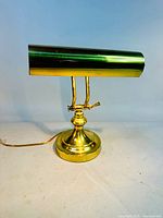 Front view of brass task lamp showing shade, arm and base