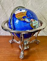 Full view of gemstone globe on silver-tone stand