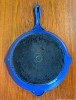 Full view of underside showing blue enamel, handle, helper handle