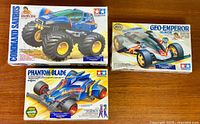 Group shot of three sealed Tamiya model kit boxes: Command Saurus, Geo-Emperor, Phantom Blade