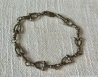 Full view of bracelet laid flat showing all equestrian bit links and clasp