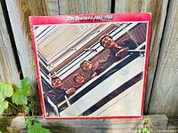 Front cover of red album showing band looking down stairwell