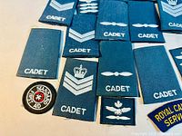 assortment of blue CADET rank slip-ons and Standard First Aid patch