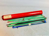 Full view of red tube and pile of assorted needles