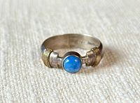 Ring front showing blue kyanite cabochon and gold rope accents