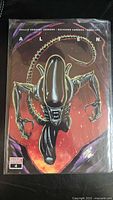 Front view of bagged Alien #4 variant comic showing cover art and issue number