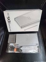 Front of retail box and bagged console with charger