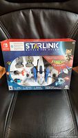 Front of boxed Starlink Battle for Atlas Nintendo Switch Starter Pack showing contents through window