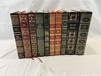 Front spines of all ten leather-bound books showing gilt decoration and titles