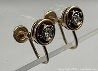 Front view of both earrings showing bezel-set diamonds and yellow gold screw-back design