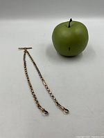 Full Albert chain beside 3-inch apple for scale