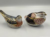 Both bird paperweights side by side