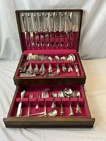 Open chest showing full 100-piece Birks Saxon flatware set in two tiers