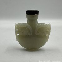 Front view showing carved dragon handles and stopper