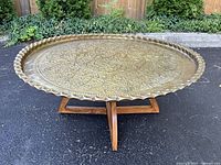 Full view of brass tray table on wooden base