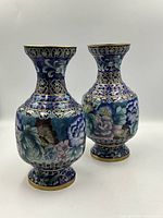 Front view of the two cloisonne vases showing floral enamel design and brass rims