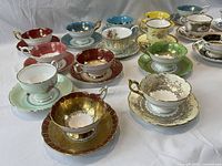 Angled view highlighting colours and gilding on cups and saucers