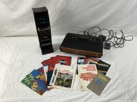 Group shot of console, cartridges, manuals, cables and holder