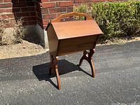 Front three-quarter view of entire wooden sewing stand closed