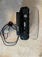 Side view of closed unit with attached power cord and plug