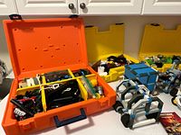 Open orange case showing sorted Construx pieces and adjacent assembled structure