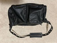 Front view showing twin zip pockets, shoulder strap, leather texture