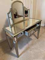 Vanity table with attached three-panel mirror, drawer open