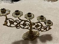 Front view showing five candle holders and ornate base