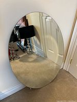 Frameless oval mirror front view leaning against wall