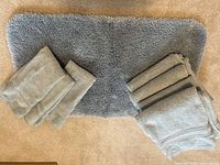 Bath mat centered with two stacks of folded pale blue towels