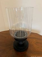 Overall view of glass hurricane candle holder on pedestal base