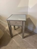 Nightstand front and side view showing mirrored surfaces and drawer