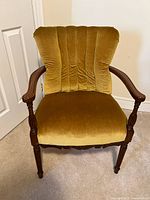 Front view showing mustard velvet upholstery, tufted back, wood arms and legs