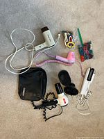 Entire lot laid out showing three hair dryers, crimper, bag, hair accessories