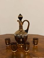 Decanter centered with four cordial glasses around it