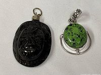 Obsidian mask pendant and turquoise pendant front view