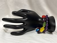 Both bracelets displayed on black hand form
