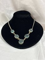 Full view of necklace on display bust showing five blue glass stones and silver chain