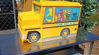 Left front three-quarter view of yellow school-bus-shaped toy box