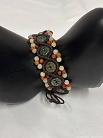 Full bracelet on display stand showing jade coins and bead pattern