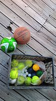 Overall lot on deck: basketball, soccer ball, crate with balls