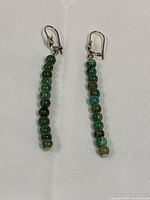 Full view of both earrings showing bead count, hooks, and sterling components