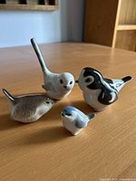 Front view of all four porcelain bird figurines