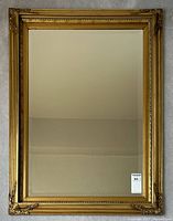 Full view of rectangular gilt framed mirror