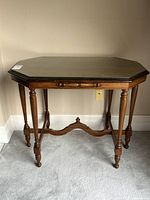 Front angled view of walnut hall table with glass top and turned legs